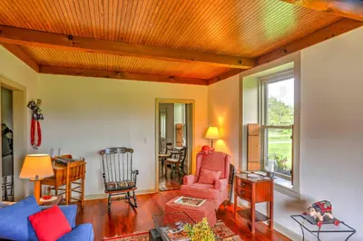 a living room with red chairs and a wooden ceiling at Historic Ottawa Lake House Deck, Barn and 96 Acres! in Sylvania