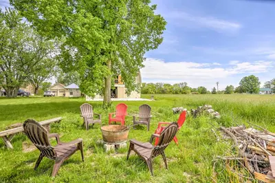 a group of chairs sitting in the grass at Historic Ottawa Lake House Deck, Barn and 96 Acres! in Sylvania