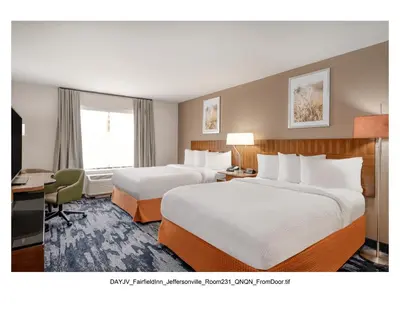 a hotel room with two beds and a desk at Fairfield Inn & Suites by Marriott Jeffersonville I-71 in Jeffersonville
