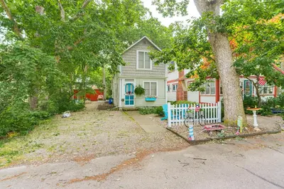 a house with a white fence and a tree at Walk to Lake Historic Lakeside Marblehead Cottage in Lakeside
