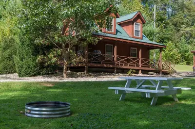 a picnic table in front of a house at Scotch Pine . Trailside Lodging in Millersburg