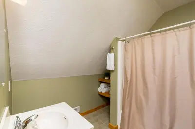 a bathroom with a sink and a shower curtain at Scotch Pine . Trailside Lodging in Millersburg