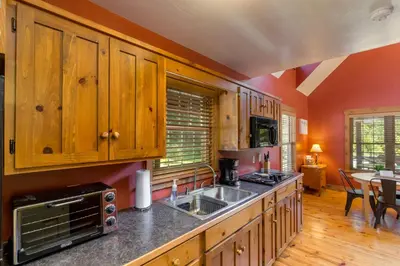 a kitchen with wooden cabinets and a sink at White Pine . Trailside Lodging in Millersburg