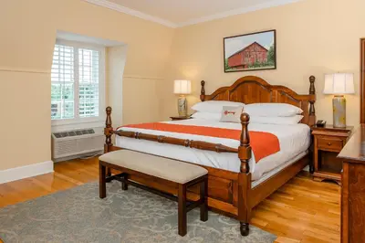 a bedroom with a large bed and a large window at Mills Park Hotel in Fairborn