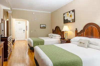 a hotel room with two beds and a television at Mills Park Hotel in Fairborn