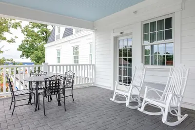 a porch with a table and chairs on it at Mills Park Hotel in Fairborn
