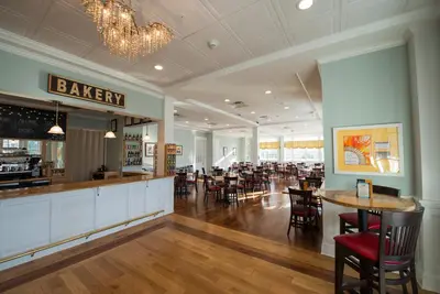 a restaurant with a bar and tables and chairs at Mills Park Hotel in Fairborn