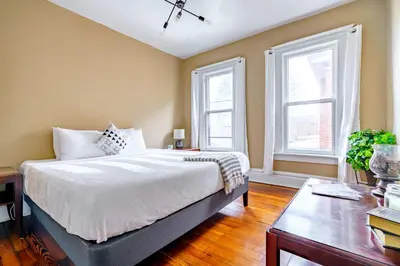 a bedroom with a large bed and two windows at Jungle House Luxury Stays - Columbus Downtown Short North in Columbus