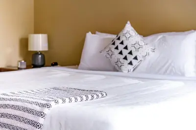 a white bed with white sheets and pillows on it at Jungle House Luxury Stays - Columbus Downtown Short North in Columbus