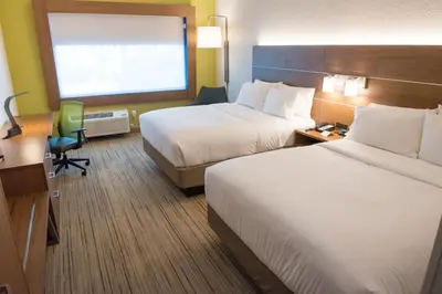 a hotel room with two beds and a desk at Holiday Inn Express & Suites Dayton North - Vandalia by IHG in Dayton