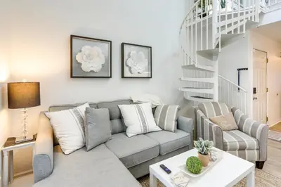 a living room with a couch and a table at Charming Condo on Lake Erie with Community Pool in Sand Beach