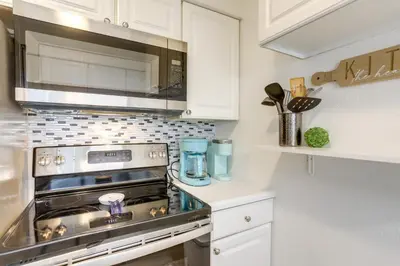 a kitchen with a stove and a microwave at Charming Condo on Lake Erie with Community Pool in Sand Beach