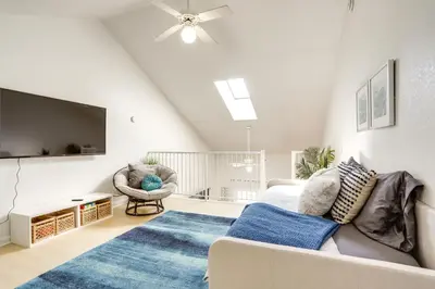 a living room with a couch and a flat screen tv at Charming Condo on Lake Erie with Community Pool in Sand Beach