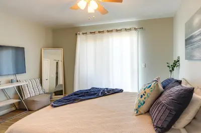a bedroom with a large bed with a large window at Charming Condo on Lake Erie with Community Pool in Sand Beach