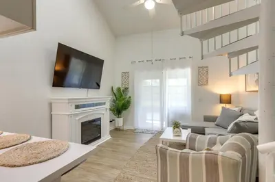 a living room with a fireplace and a tv at Charming Condo on Lake Erie with Community Pool in Sand Beach