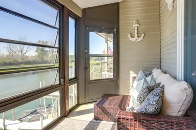 a screened in porch with a couch and windows at Charming Condo on Lake Erie with Community Pool in Sand Beach