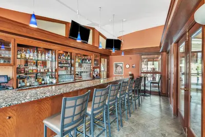 a bar in a restaurant with blue chairs at The Inn at Ohio Northern University in Ada