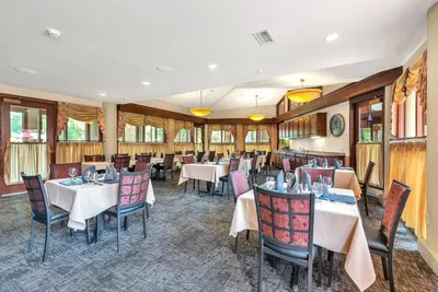 a dining room with tables and chairs and windows at The Inn at Ohio Northern University in Ada