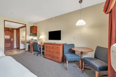 a hotel room with a bed and a desk with a television at The Inn at Ohio Northern University in Ada