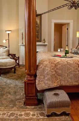 a bedroom with a large bed with a wooden post at Riverside Inn Bed and Breakfast, Wedding Venue & Events in Warsaw