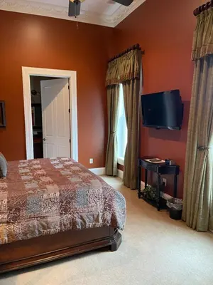 a bedroom with a bed and a flat screen tv at Riverside Inn Bed and Breakfast, Wedding Venue & Events in Warsaw