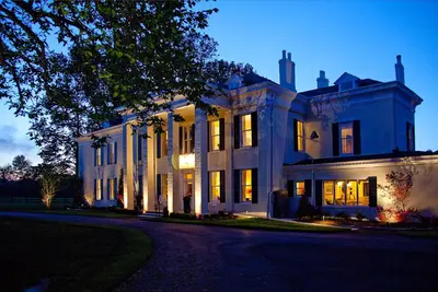 a large white house with its lights on at Riverside Inn Bed and Breakfast, Wedding Venue & Events in Warsaw
