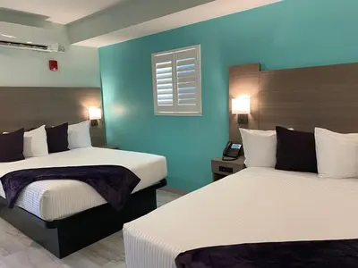 a hotel room with two beds and a blue wall at Worthington of Logan in Logan