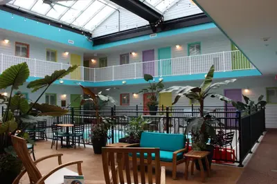 a lobby with tables and chairs and potted plants at Worthington of Logan in Logan