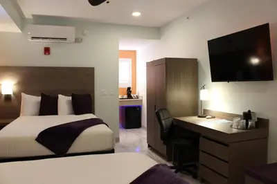 a bedroom with a bed and a desk and a television at Worthington of Logan in Logan
