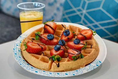 a waffle with strawberries and blueberries on a plate at Hampton Inn & Suites Canal Winchester Columbus in Canal Winchester