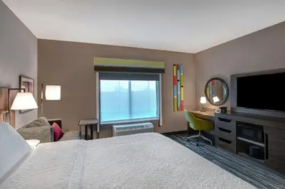 a hotel room with a bed and a flat screen tv at Hampton Inn & Suites Canal Winchester Columbus in Canal Winchester