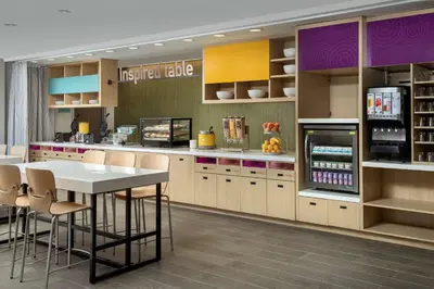 a kitchen with a table and chairs and a refrigerator at Home2 Suites By Hilton Columbus Polaris in Columbus