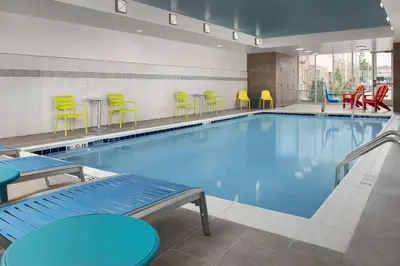 a swimming pool with colorful chairs and tables at Home2 Suites By Hilton Columbus Polaris in Columbus