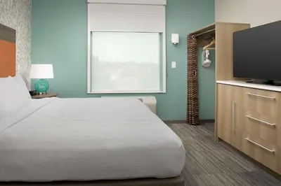 a bedroom with a large bed and a flat screen tv at Home2 Suites By Hilton Columbus Polaris in Columbus