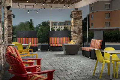 a patio with colorful chairs and tables and a fire pit at Home2 Suites By Hilton Columbus Polaris in Columbus