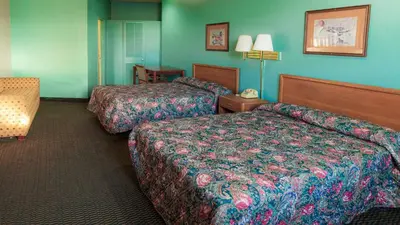 two beds in a hotel room with blue walls at Red Horse Motel Dayton Moraine in Dayton