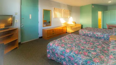 a hotel room with two beds and a flat screen tv at Red Horse Motel Dayton Moraine in Dayton