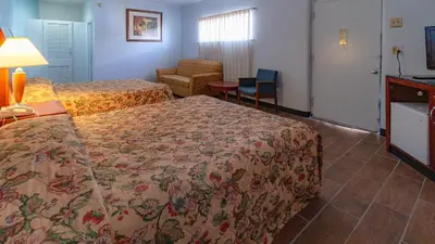 a hotel room with two beds and a table at Red Horse Motel Dayton Moraine in Dayton