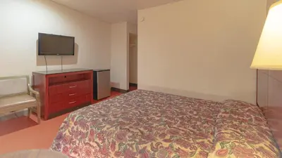 a hotel room with a bed and a flat screen tv at Red Horse Motel Dayton Moraine in Dayton