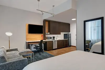 a hotel room with a bed and a desk and a kitchen at TownePlace Suites by Marriott Cincinnati Downtown in Cincinnati
