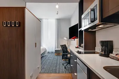 a hotel room with a kitchen and a bedroom at TownePlace Suites by Marriott Cincinnati Downtown in Cincinnati