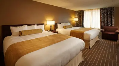 a hotel room with two beds and a chair at Mountaineer Casino Resort in New Cumberland