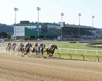 a group of horses racing on a race track at Mountaineer Casino Resort in New Cumberland