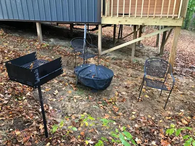 two chairs and a trash can in a yard at Avenwood Cabins in Logan