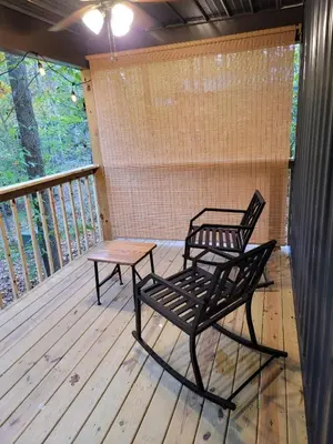 two chairs and a table on a deck at Avenwood Cabins in Logan