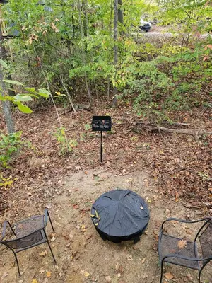 a black umbrella and two chairs and a sign at Avenwood Cabins in Logan