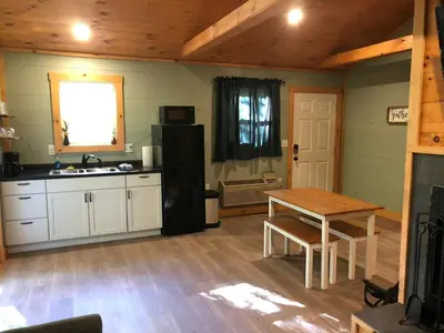 a kitchen with a table and a sink and a refrigerator at Avenwood Cabins in Logan