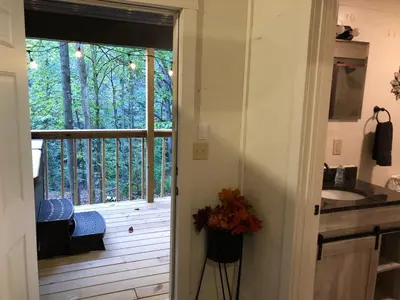 a bathroom with a deck with a sink and a window at Avenwood Cabins in Logan
