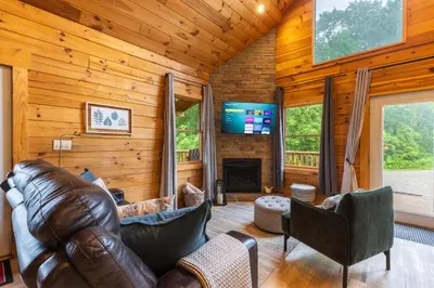 a living room with a leather couch and a fireplace at Family Friendly ~ Hocking Hills Cabin ~ Close to Caves, w/Wifi in South Bloomingville