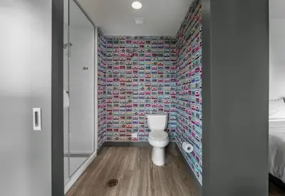 a bathroom with a toilet and a mosaic wall at Aloft Columbus Easton in Columbus